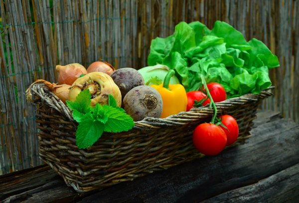 Woven basket full of produce from a vegetable garden.